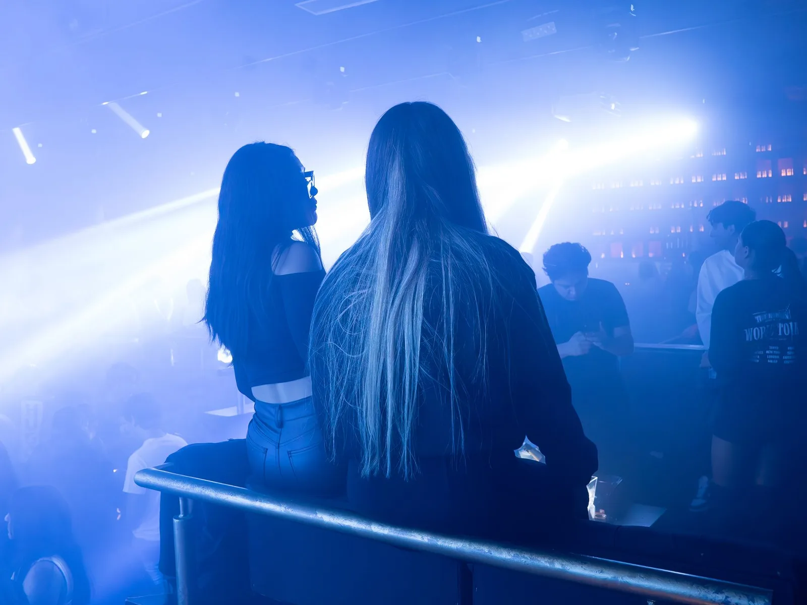 Guests at a late-night club under blue stage lights