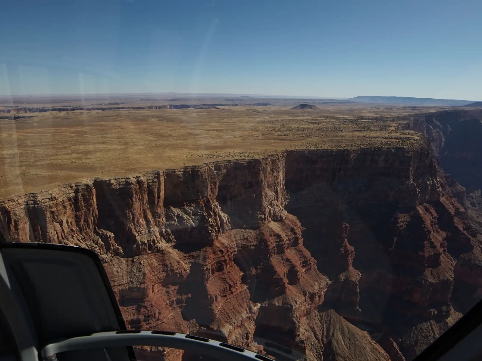 The Grand Canyon seen through a helicopter windscreen, the rim falling away below