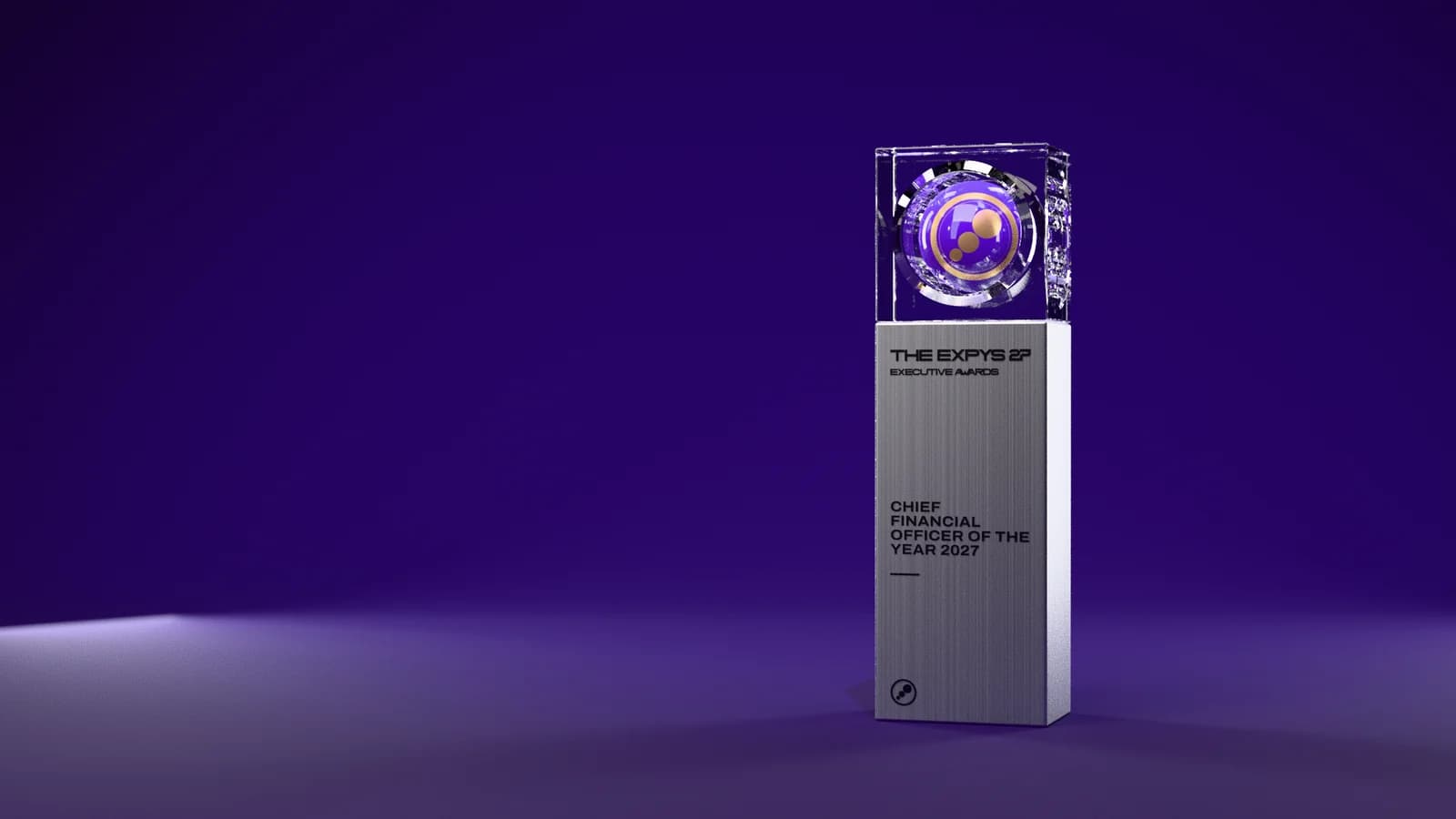 The Executive Awards trophy on a dark violet stage: a crystal block holding the Expys sphere, on a brushed steel pillar engraved with the award title, Chief Financial Officer of the Year 2027