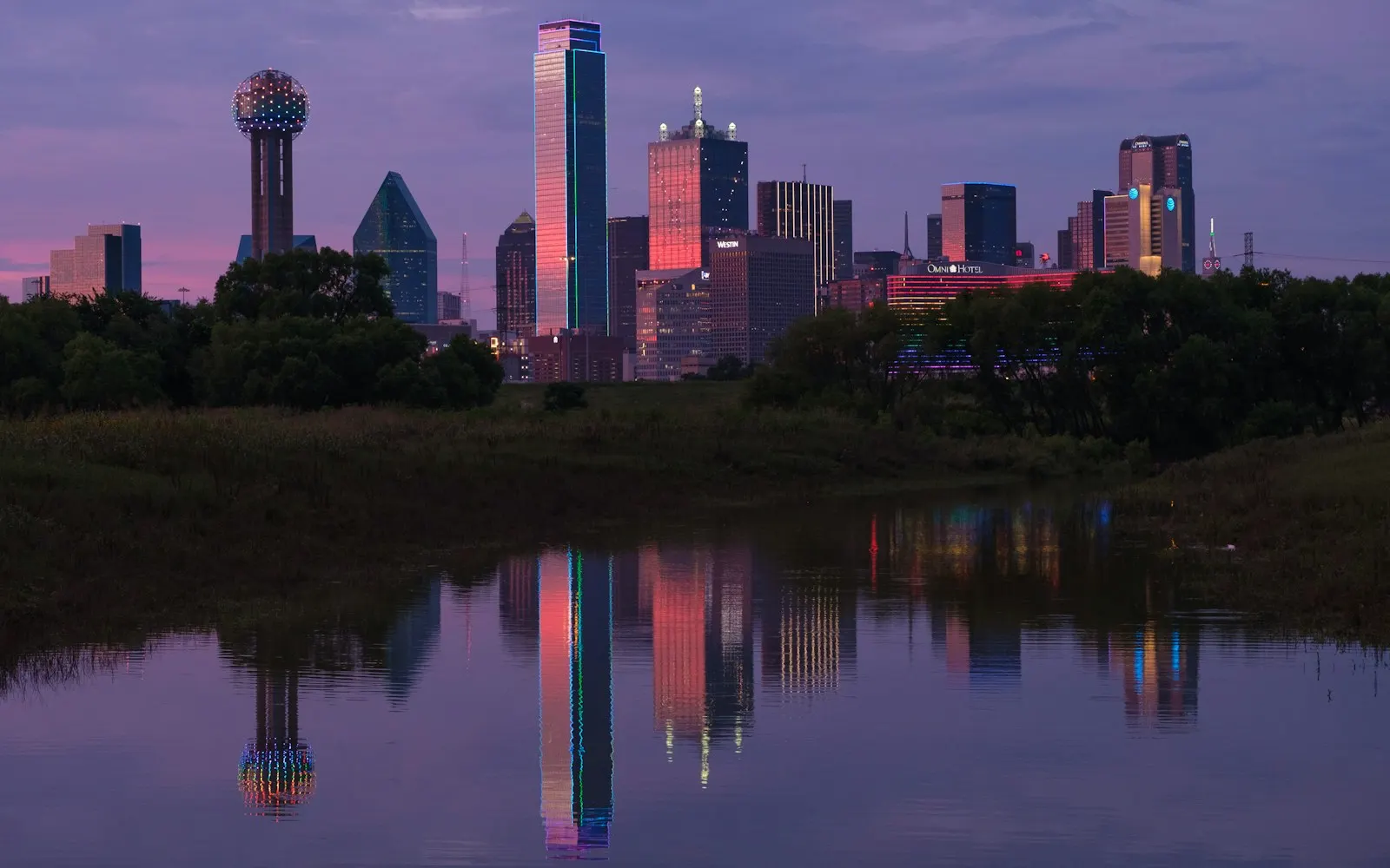 The Dallas skyline at dusk, reflected in still water