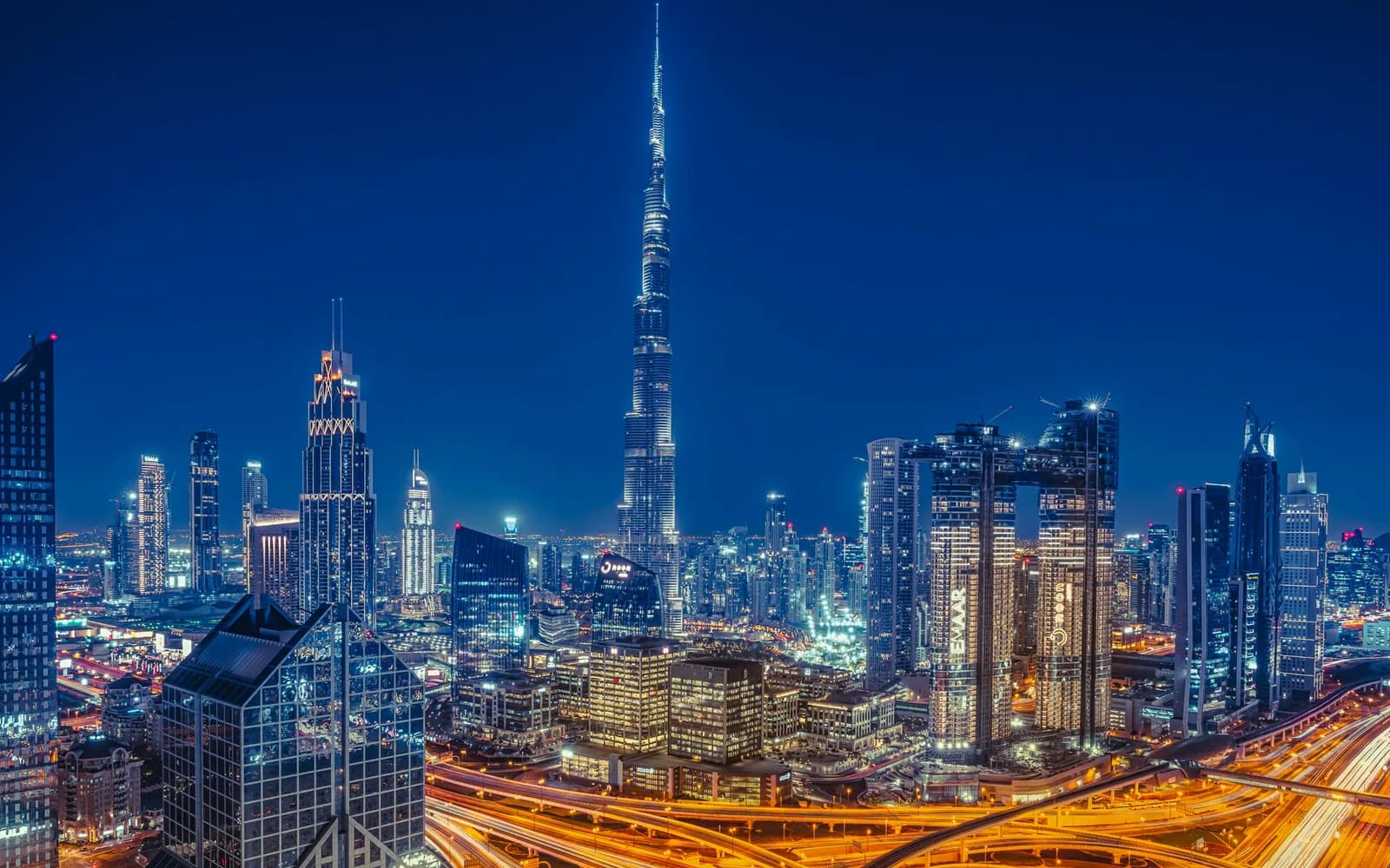 The Burj Khalifa over Downtown Dubai at night, the highways lit below