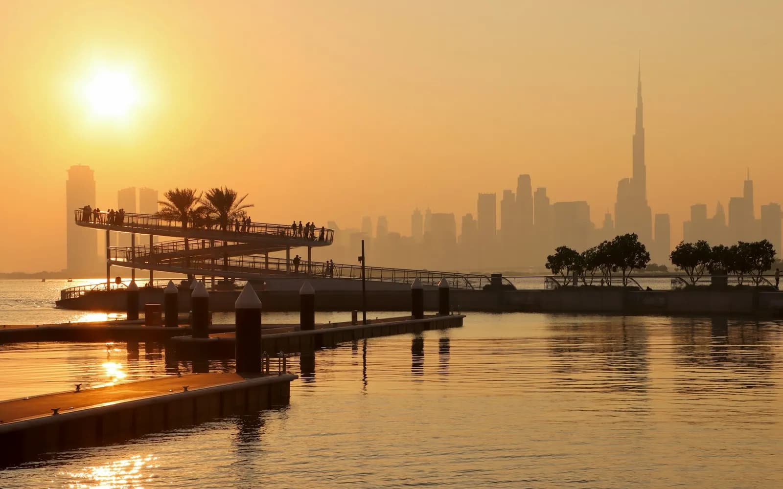 The Dubai skyline at sunset across the water